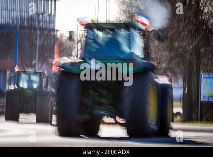 Schwerin, Allemagne.28th janvier 2022.Un policier contrôle la circulation à un carrefour, tandis que les tracteurs protestent contre la nouvelle ordonnance sur les engrais pendant un entraînement à colonne.(Long coup de feu) plus de 300 tracteurs étaient dans les rues de la capitale de l'État pendant l'action des agriculteurs contre le nouveau projet de l'ordonnance sur les engrais de l'État et pour une protection efficace des eaux souterraines, causant des embouteillages et des obstructions.Credit: Jens Büttner/dpa-Zentralbild/dpa/Alay Live News Banque D'Images