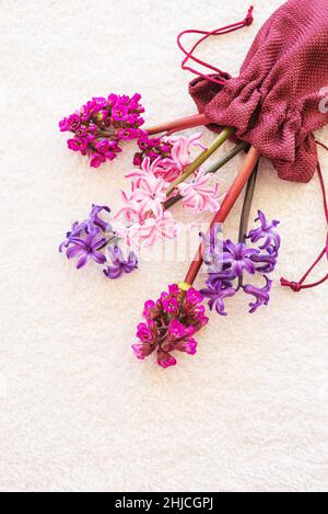 Bouquet de fleurs violet, bleu et rose sur fond de tissu blanc en peluche. Banque D'Images