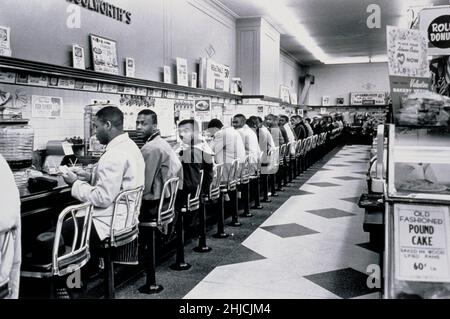 9 février 1960, Charlotte, Caroline du Nord. Les étudiants avaient dit au chef de police ce qu'ils allaient faire à l'avance. Le chef de la police avait promis de ne pas procéder à des arrestations s'ils le faisaient de manière ordonnée et il a gardé sa parole; aucune police n'a jamais comparu devant les sit-ins de Charlotte et il n'y a pas eu d'arrestations. Après quelques heures, les étudiants sont partis et les magasins ont mis des affiches indiquant que leurs comptoirs de repas étaient temporairement fermés. Sur 3 juillet, les comptoirs de Woolworth ont été rouverts à tout le monde. Banque D'Images