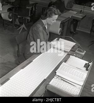 Production de timbres-poste en 1950s.Une jeune femme au timbre suédois printworks du poste suédois passe soigneusement par les timbres Gustaf VI Adolf récemment imprimés pour trouver et retirer les échantillons défectueux.La feuille de timbres est ensuite transformée en rouleaux de 100 ou 500 timbres.Suède 1951 Kristoffersson réf. bc45-8 Banque D'Images