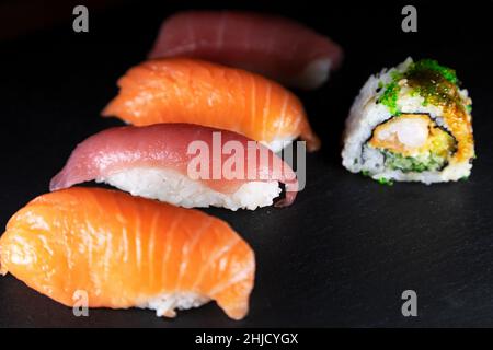 Un plateau de nigiri de thon et de saumon servi avec de l'uramaki.Types de sushis, le plat est originaire du Japon. Banque D'Images