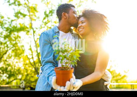 couple afro-américain jardinant à l'extérieur au coucher du soleil jour de printemps ensoleillé Banque D'Images