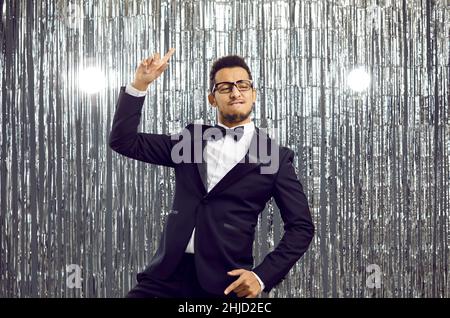 Joyeux drôle jeune homme dans un costume élégant et Bowtie dansant et s'amuser à une fête Banque D'Images