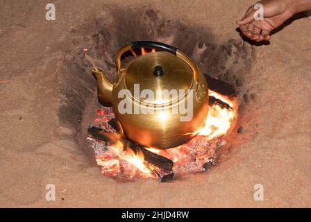 Une grande bouilloire en laiton dans un feu de camp pour le chauffage de l'eau pour le café Banque D'Images