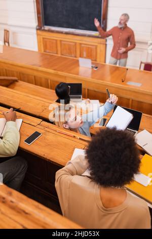 Vue en hauteur du carnet d'étudiants près d'un ami afro-américain dans l'auditorium de l'université Banque D'Images