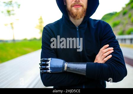 homme avec prothèse de bras dans des vêtements de sport prêts pour l'entraînement matinal à l'extérieur.Concept de sport pour handicapés Banque D'Images