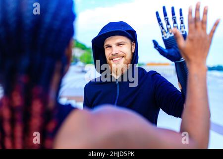 homme avec prothèse de bras dans des vêtements de sport prêts pour l'entraînement matinal à l'extérieur.Concept de sport pour handicapés Banque D'Images