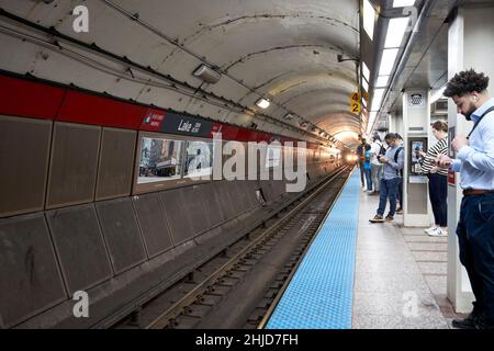 les passagers regardant vers le bas des téléphones attendent le train sur la longue plate-forme sur la ligne rouge cta station du lac la plus longue en amérique du nord chicago illinois unis Banque D'Images