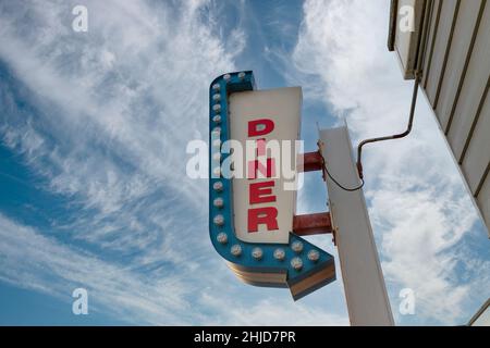 Panneau de restaurant au néon contre un ciel bleu. Banque D'Images