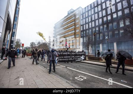 Les manifestants ont tenu une marche en bannière vers la ligne de front de la police dans la rue de la Loi Wet lors de la manifestation.la fin de la manifestation de dimanche dans la ville belge de Bruxelles et au cœur de l'Union européenne a été entachée par une petite minorité qui n'a eu qu'un penchant pour la violence.Plus de 50 000 manifestants venus de toutes les parties de l'Europe ont participé à une manifestation contre le coronavirus anti-gouvernement, qui s'est passée sans incident.Une violente minorité vêtue de noir, renversait le district européen, ils ont vandalisé des voitures, des pierres ont été catapultés et lancées et des panneaux routiers déracinés, devant l'EEAS «Europe Banque D'Images