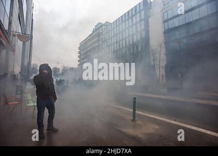 Un manifestant se tient au milieu de la fumée des gaz teargas pendant la manifestation.la fin de la manifestation de dimanche dans la ville belge de Bruxelles et au cœur de l'Union européenne a été marquée par une petite minorité qui n'était qu'un sujet de violence.Plus de 50 000 manifestants venus de toutes les parties de l'Europe ont participé à une manifestation contre le coronavirus anti-gouvernement, qui s'est passée sans incident.Une violente minorité vêtue de noir, renversait le district européen, saccagé des voitures, saccagé des pierres et jeté des panneaux routiers, l'avant du bâtiment du « Service européen pour l'action extérieure » de l'EEAS était totalement démoli Banque D'Images