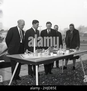 1960, conseillers historiques locaux regardant un modèle à l'échelle d'un nouveau complexe industriel proposé exposé à l'extérieur sur table, une nouvelle usine de gaz de Lurgi avec tours de refroidissement, qui sera construite sur le site de l'ancienne mine de fonte ouverte à Westfield, Fife, Écosse, Royaume-Uni.Près du village de Kinglaisse, la mine Westfield, qui a été exploitée pendant près de cinquante ans, était la plus grande et la plus longue mine d'opencast de l'histoire britannique. Banque D'Images