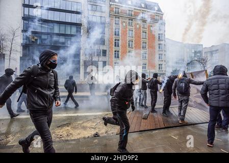 Bruxelles, Belgique.23rd janvier 2022.Les manifestants font face à la police avec du verre, des pierres et des parties de barricades improvisées au milieu de la fumée des gaz. La manifestation de fin de dimanche dans la ville belge de Bruxelles et au cœur de l'Union européenne a été entachée par une petite minorité qui n'a fait que se battre.Plus de 50 000 manifestants venus de toutes les parties de l'Europe ont participé à une manifestation contre le coronavirus anti-gouvernement, qui s'est passée sans incident.Une violente minorité vêtue de noir, renversait le district européen, ils ont vandalisé des voitures, des pierres ont été catapultées et jetées et la route Banque D'Images