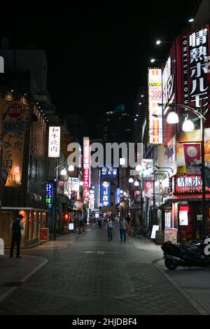 Vue nocturne de la rue étroite à Ikebukuro, Toshima, Tokyo avec des panneaux de rue Banque D'Images