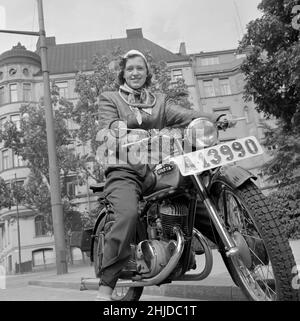 Motocycliste dans les années 1950 Une jeune femme sur sa moto habillée comme le motocycliste typique des années 1950 devrait porter une veste en cuir et une ceinture rénale. La moto est une Sparta. Suède 1951 conduire une moto. Banque D'Images