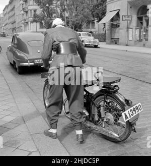 Motocycliste en 1950s.Une jeune femme avec sa moto habillée comme le motocycliste typique de la 1950s devrait avec une veste en cuir et une ceinture de rein.Suède 1951 Banque D'Images