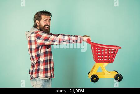 homme mûr beau en chemise à carreaux porte chariot, achat Banque D'Images