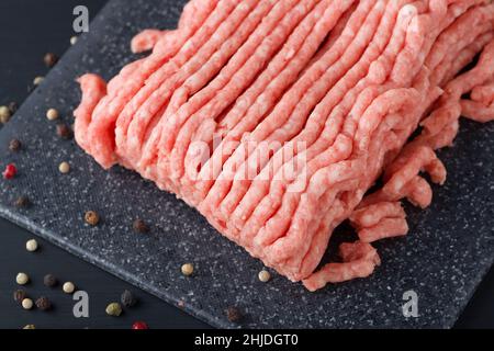 Bœuf haché frais dans une assiette près d'une table en bois rustique Banque D'Images