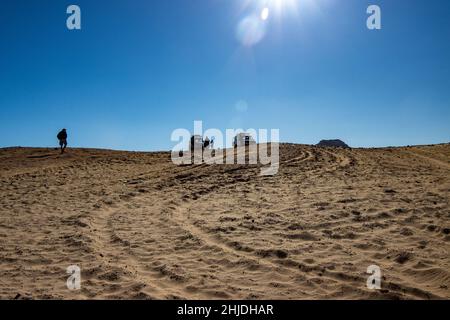 Deux Toyota Landcruisers au sommet d'une dune de sable, les gens marchant vers les voitures Banque D'Images