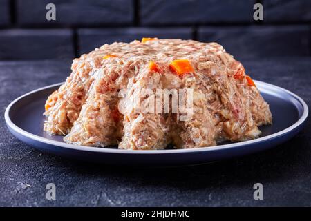 viande de porc et de poulet aspique, gelée viande cuite lentement sur une assiette sur une table en béton avec un mur de brique noire à l'arrière-plan, gros plan Banque D'Images