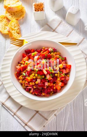 Vinegret, vinaigrette russe, salade de betteraves rouges cuites en dés, pommes de terre, carottes, oignons hachés, cornichons sautés,pois verts dans un bo blanc Banque D'Images