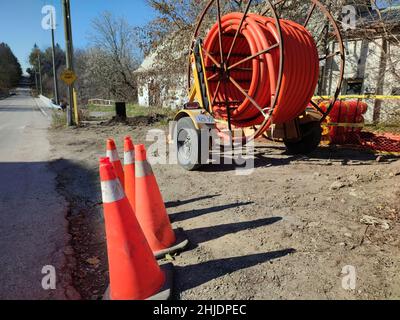 Cône de circulation et tuyaux orange pour fibre optique dans une construction urbaine Banque D'Images