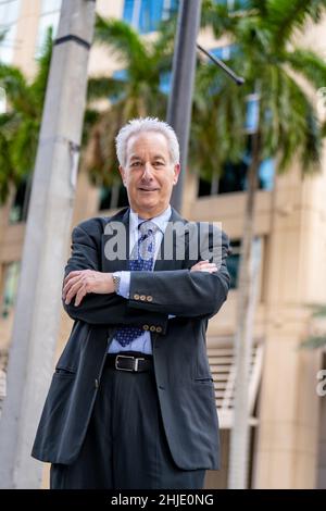 Beau homme d'affaires posant avec les armes croisées Banque D'Images