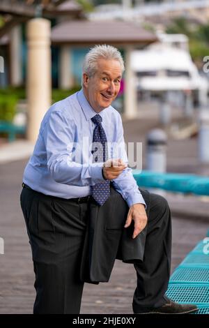 Sourire homme d'affaires doigt à l'appareil photo.L'homme porte une chemise et une cravate bleues Banque D'Images