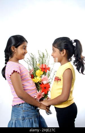 Mumbai Inde Asie juin.05 2008 charmante petite fille indienne présentant bouquet de fleurs à son ami célébrant son anniversaire. Banque D'Images