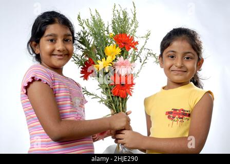 Mumbai Inde Asie juin.05 2008 charmante petite fille indienne présentant bouquet de fleurs à son ami célébrant son anniversaire. Banque D'Images