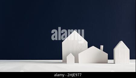 Petites maisons de jouets en bois blanc sur fond noir.Décoration scandinave minimaliste Banque D'Images