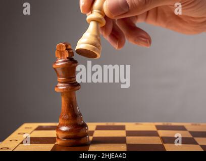 Concept de stratégie d'entreprise.Knight faisant la dernière étape pour faire le checkmate dans les échecs, tombant roi. Banque D'Images