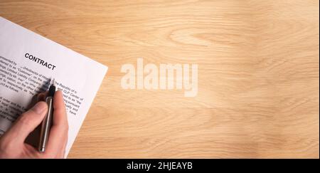 Remettre le contrat légal ou l'accord avec la place pour le texte sur le bureau en bois, vue de dessus. Banque D'Images