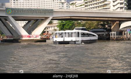 LE FERRY intelligent DE LA MINE, la rivière Chao Phraya de catamaran électrique, Bangkok, Thaïlande Taksin Bridge aka Sathon Bridge en arrière-plan Banque D'Images