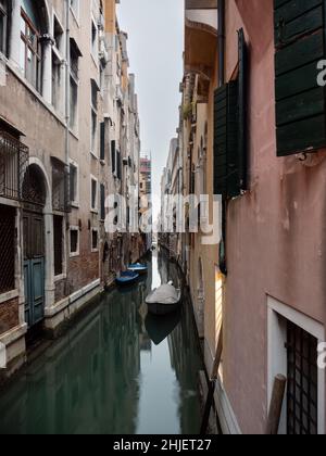 Petit canal avec des bateaux à Venise, en Italie, lors d'une froide journée d'hiver Banque D'Images