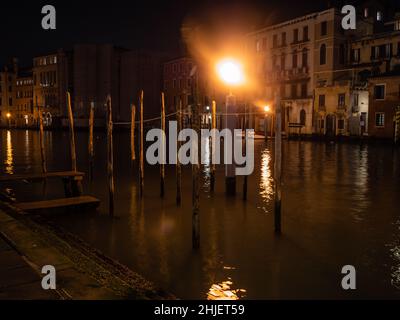 Amarre des postes sur le Grand Canal ou Canal Grande à Venise, Italie illuminés la nuit Banque D'Images