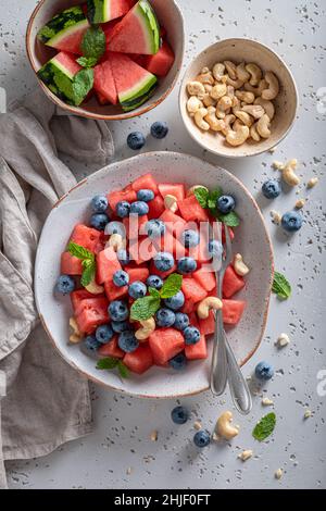 Délicieuse salade de pastèques à base d'ingrédients frais et sains.Salade de pastèque aux noix et aux baies Banque D'Images
