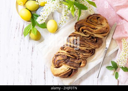 Pâtisserie de Pâques.Babka au chocolat de Pâques ou pain brioche maison.Pâte de levure sucrée avec garniture au chocolat et accompagnée de noix sur une table en bois. Banque D'Images