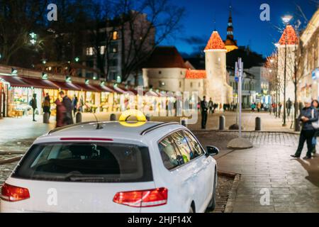 Tallinn, Estonie. Taxi Voiture Stationnement près de portes Viru Entrée de la vieille ville de la capitale estonienne. Célèbre De la Porte Viru dans l'éclairage des rues à soir Banque D'Images
