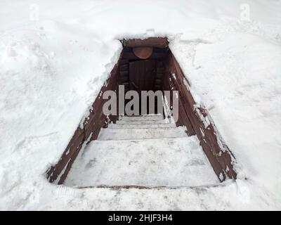 Dugout partisan en forêt d'hiver.Terre-maison construite par des partisans soviétiques dans la forêt ukrainienne pendant la guerre mondiale de Secont. Banque D'Images