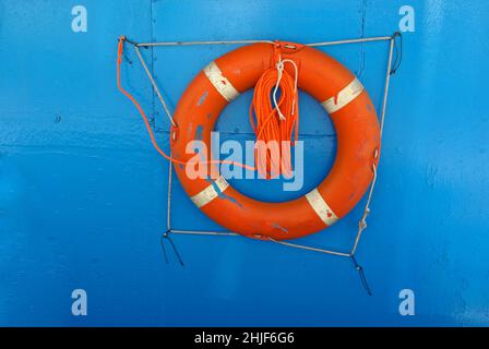 Bouée de sauvetage et corde accrochée au mur bleu du bateau. Banque D'Images