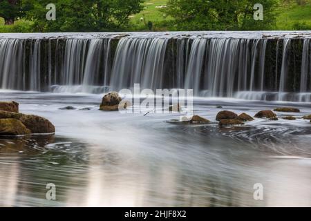 Vue d'été sur le weir du Boston Spa sur la rivière Wharfe avec un faible débit d'eau au-dessus du weir Banque D'Images