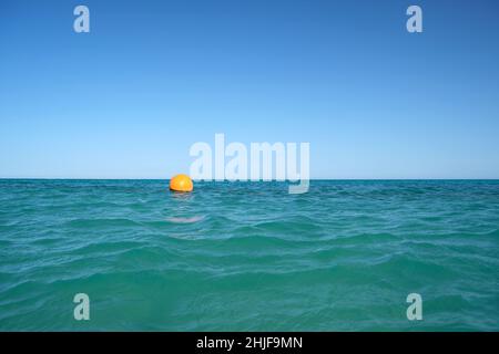 Bouée orange flottant sur les vagues de la surface de la mer.Concept de sécurité de la vie humaine. Banque D'Images