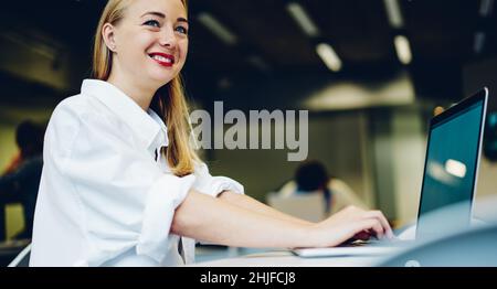Bonne femme avec un ordinateur portable au bureau Banque D'Images