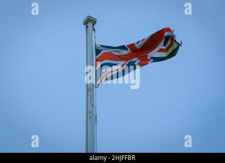 drapeau britannique flatté volant haut dans le ciel bleu Banque D'Images