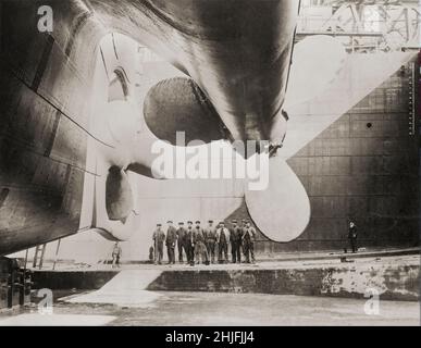 Une photographie vintage des travailleurs de chantier naval et des propulseurs qui ont conduit RMS Titanic, le paquebot britannique, avant son lancement en 1911.Exploité par la ligne White Star, qui a coulé dans l'océan Atlantique Nord le 15 avril 1912 après avoir heurtés un iceberg lors de son premier voyage de Southampton, Royaume-Uni, à New York.Sur les 2 224 passagers et membres d'équipage estimés à bord, plus de 1 500 sont morts, ce qui a fait du naufrage l'un des plus mortels pour un seul navire jusqu'à cette époque. Banque D'Images