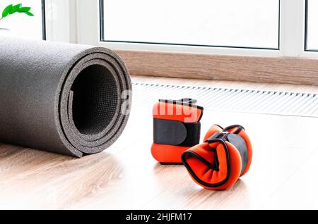 Concept sportif pour le sport à la maison. Tapis de fitness, poids pour les bras et les jambes, harnais pour le fitness Banque D'Images