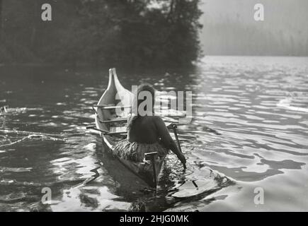 Edward S Curtis photographie - Clayoquot Indian pagayer canoë dans la zone ombragée par des arbres - 1910 Banque D'Images