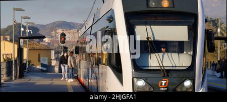 Villajoyosa Alicante Espagne 01.29.22 Tram à la gare.Deux filles portant un masque facial et un Jean déchiré attendent à bord.Haut-parleur femelle avec verres foncés. Banque D'Images