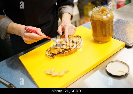 Chef mettant des morceaux de foie sur un morceau de pain frit Banque D'Images